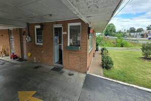 A small, single-story building with a brick facade, a covered entrance, and a visible door.