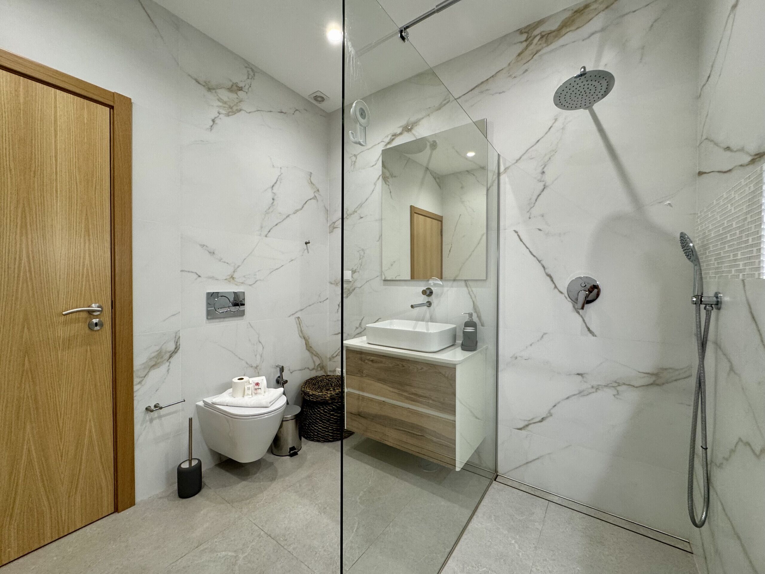 Ein modernes Badezimmer mit Toilette, Waschbecken und Dusche.