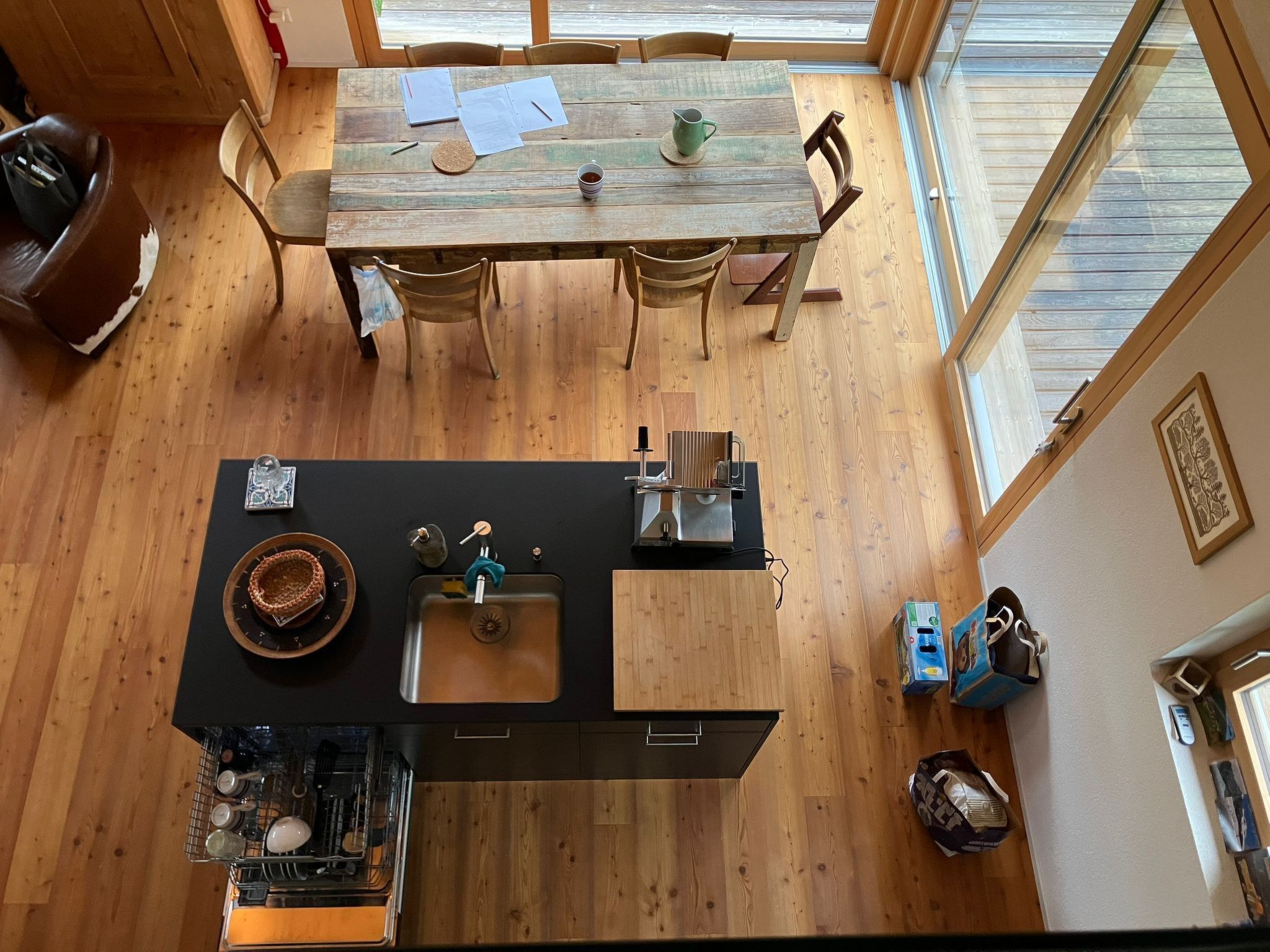A modern kitchen with a wooden dining table, a built-in sink, and a dishwasher.
