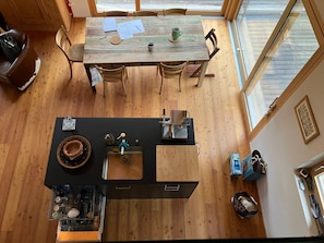 Eine moderne Küche mit einer zentralen Kochinsel, Holzboden und einem Essbereich mit Tisch und Stühlen.