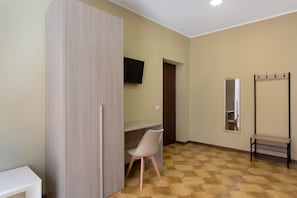 A room with a wardrobe, a desk with a chair, a television mounted on the wall, a mirror, and a coat rack. - Dimora Sophia Nicole: In the Heart of Catania’s Charm (Catania)