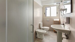 Un bagno moderno con toilette, bidet e lavabo.
