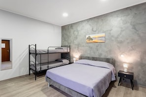 A room with bunk beds, a bed, a nightstand, a wall-mounted lamp, and a painting. - Dimora Sophia Nicole: In the Heart of Catania’s Charm (Catania)