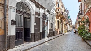 Una calle estrecha flanqueada por edificios con diversos estilos arquitectónicos, bajo un cielo despejado.