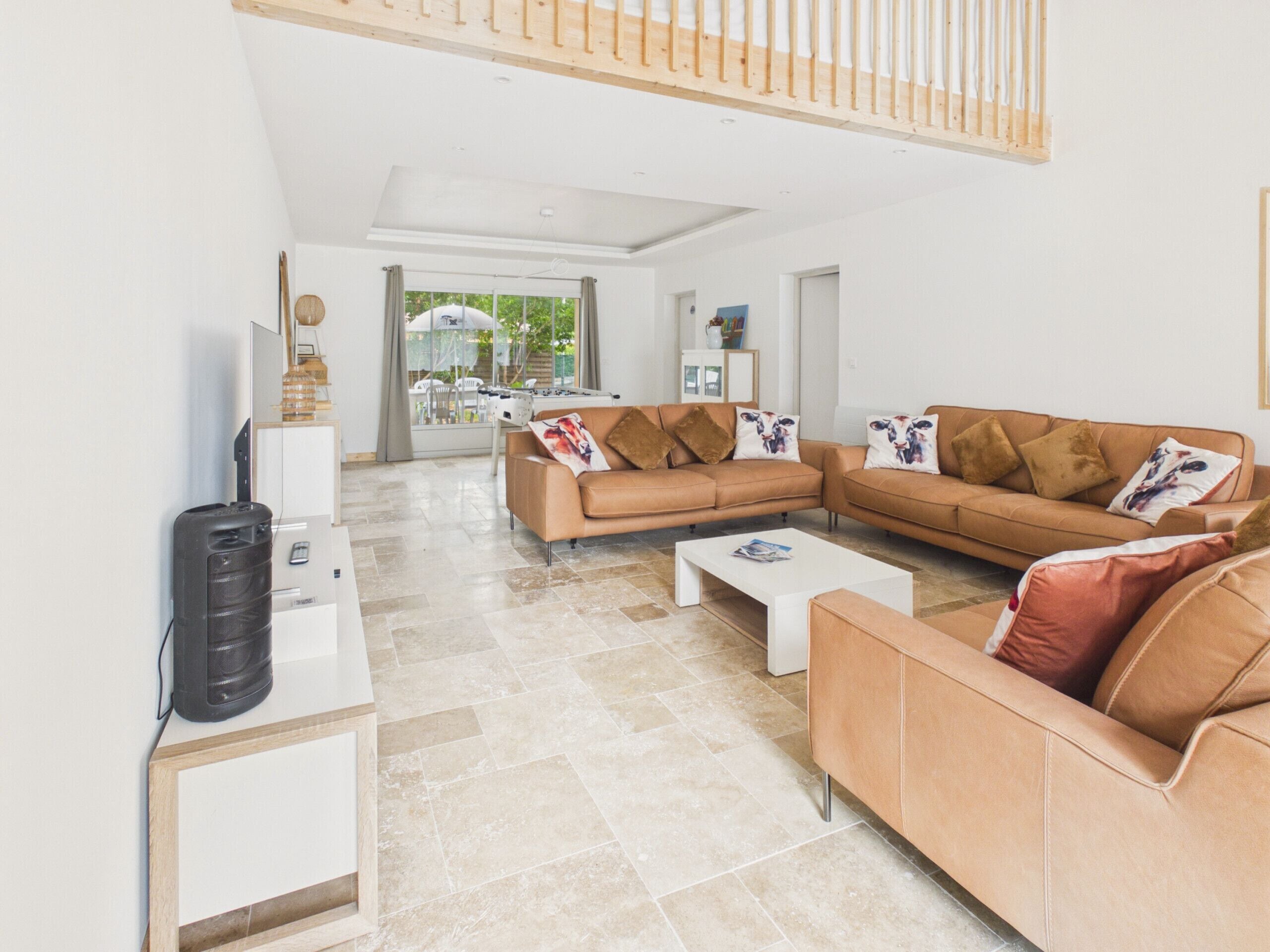 A modern living room with a sectional sofa, a coffee table, and a TV stand.