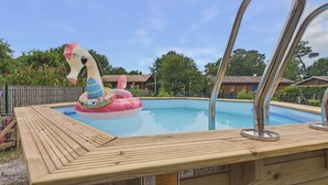 A swimming pool with a wooden deck and a large inflatable swan float. - Pool, garden & kids’ games – House for 6 (Lanton)