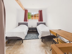 A small, modern bedroom with two single beds, a wooden table, and a bench. - Pool, garden & kids’ games – House for 6 (Lanton)
