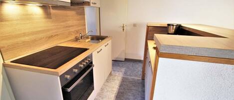 A compact kitchen with a built-in oven, a microwave, and a sink.