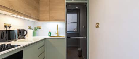 A modern kitchen with wooden cabinets, a built-in oven, and a black refrigerator.