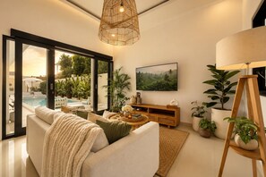 Ein modernes Wohnzimmer mit einer Couch, einem Couchtisch und Topfpflanzen.