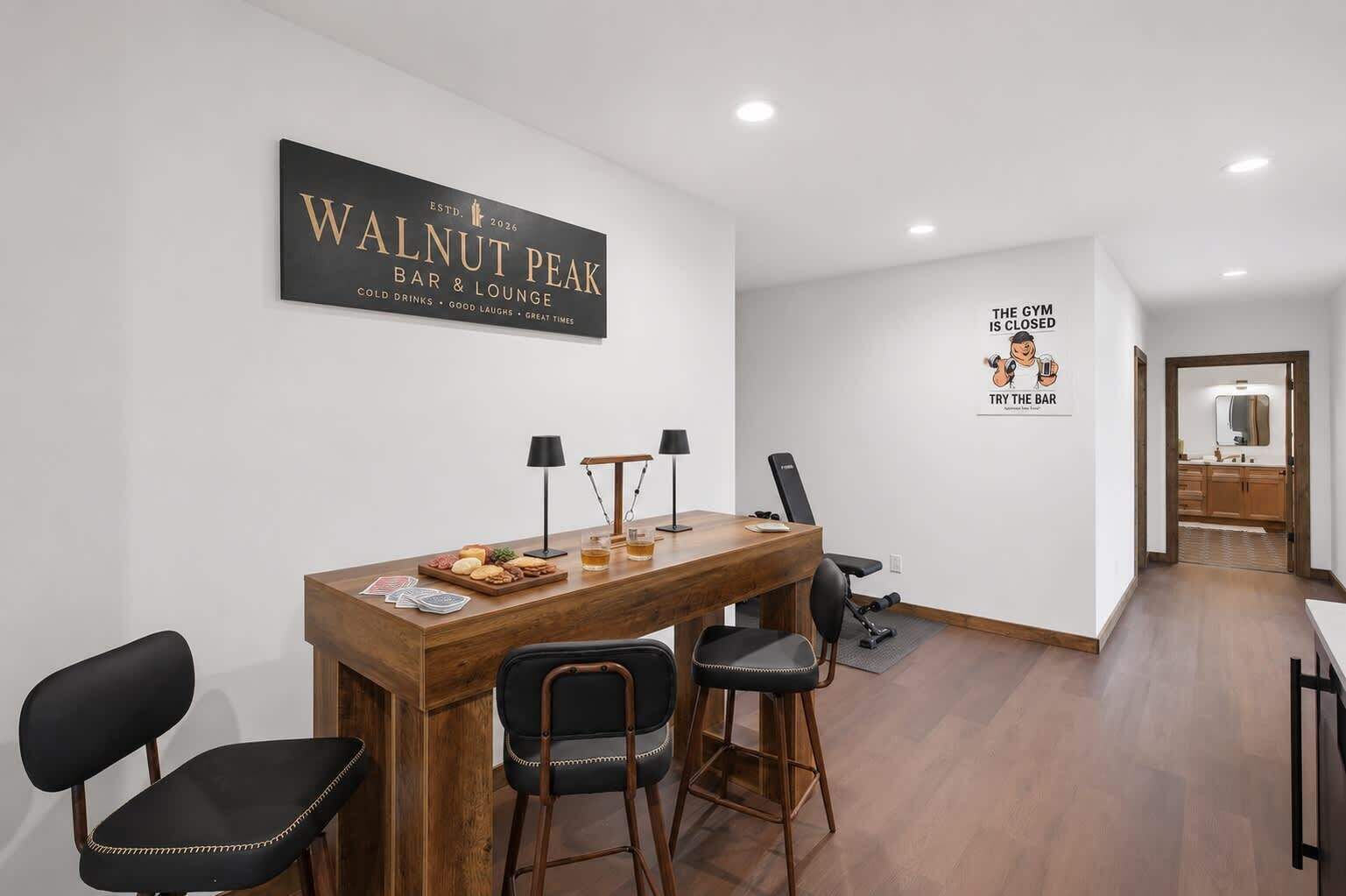 A modern bar/lounge area with a wooden table, chairs, and a sign for Walnut Peak Bar & Lounge.