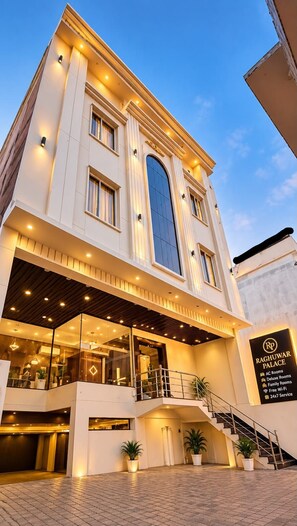 A modern hotel with a central atrium, multiple floors, and a staircase leading to the entrance.