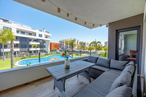 A balcony with a pool, outdoor furniture, and a view of surrounding buildings. - Charming 2-bedroom apartment with AC in tranquil Villamartín (Villamartín)