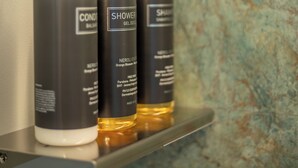 Three bottles of shower gel on a shelf. - Luxury Boutique Apartment 2 in Palermo City Center with an Amazing View (Palermo)