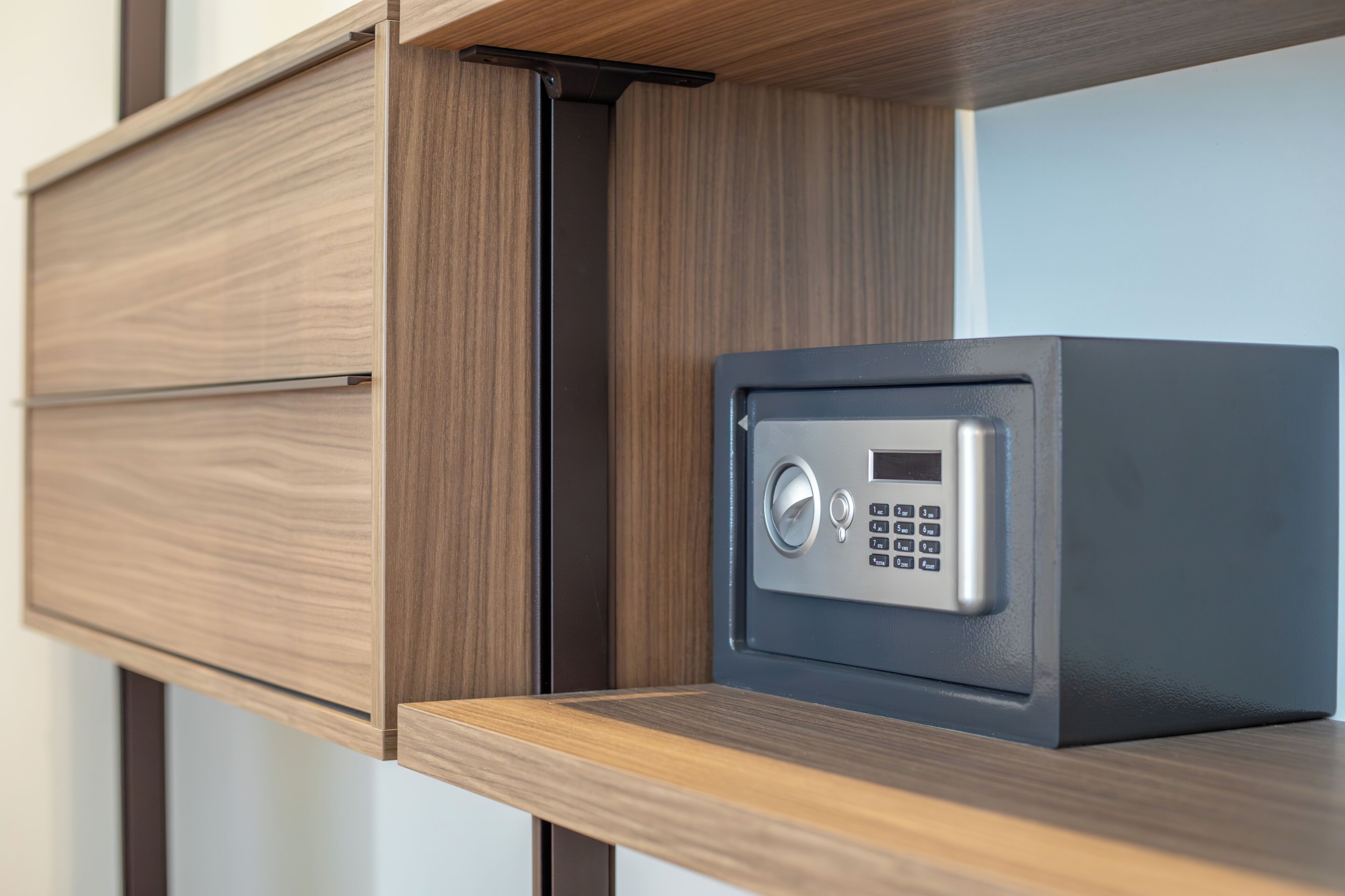 A wooden drawer unit with a built-in safe.