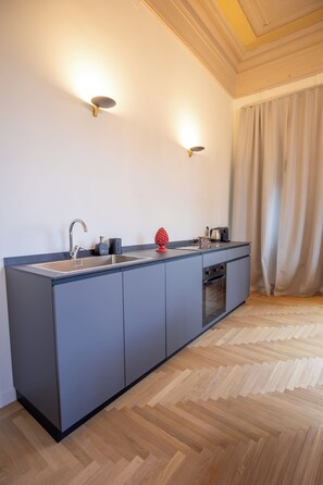 A modern kitchen with a built-in oven, a sink, and a coffee maker.