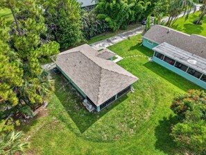 A residential property with a large, single-story house featuring a sloped roof and a well-maintained lawn.
