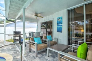 A covered patio area with outdoor furniture, a ceiling fan, and a grill. - Vacation Rental Near Downtown Sarasota & Area Beaches with Private Pool (Sarasota)