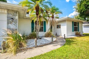 A two-story house with a stone facade, green shutters, and a gravel pathway leading to the entrance. - Vacation Rental Near Downtown Sarasota & Area Beaches with Private Pool (Sarasota)