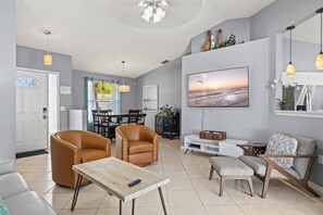 A modern living room with a television, seating, and a dining area. - Vacation Rental Near Downtown Sarasota & Area Beaches with Private Pool (Sarasota)