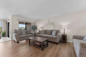 A living room with two sofas, a coffee table, and a lamp.