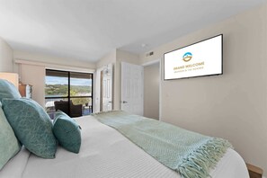 A bedroom with a bed, pillows, a TV mounted on the wall, and a balcony with a view. - Treasured Lake Views - 2 Patios (Kimberling City)
