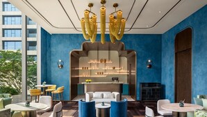 Een moderne lounge met een centrale zithoek, een barruimte met planken, en uitzicht op de omgeving.