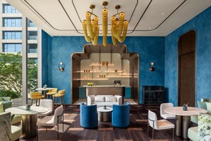 Un área de estar moderna con una disposición central de asientos, una zona de bar con estanterías y vistas al exterior.