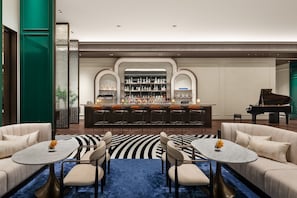 A bar area with a piano, bar stools, and a seating area with sofas and tables. - Le Méridien Taipei Banqiao (New Taipei City)