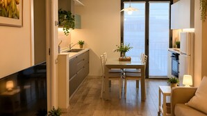 En moderne lejlighed med spiseplads, køkken og opholdsstue.