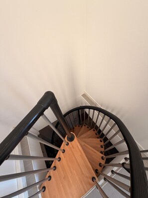 Eine Wendeltreppe mit Holzstufen und Metallgeländern.