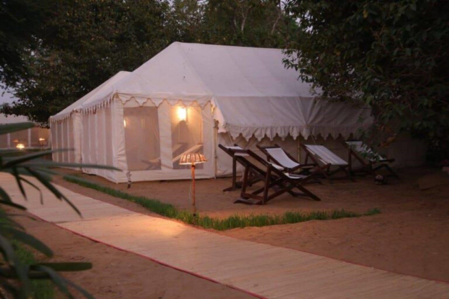 A tent with a covered seating area and a pathway leading to it.