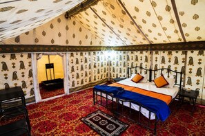 A tent-style room with a bed, a chair, and a small table. - Kumbh India Kutir (Trimbak)