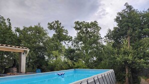 A swimming pool with a pergola and lounge chairs, surrounded by trees. - Villa 130 m², piscine au calme absolu – 8 pers. – Brignoles Var – DISPO AOÛT (Brignoles)