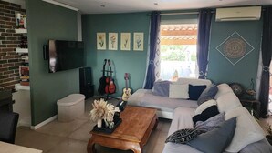 A living room with a sofa, coffee table, and a television. - Villa 130 m², piscine au calme absolu – 8 pers. – Brignoles Var – DISPO AOÛT (Brignoles)