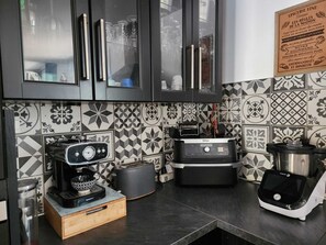 A kitchen with modern appliances, including a coffee maker, toaster, and blender, with patterned tiles on the backsplash. - Villa 130 m², piscine au calme absolu – 8 pers. – Brignoles Var – DISPO AOÛT (Brignoles)