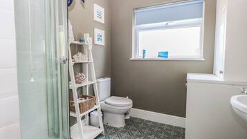 Un baño con ducha, inodoro y lavamanos.