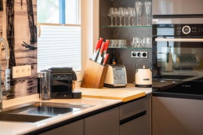 Eine moderne Küche mit eingebautem Ofen, einer Kaffeemaschine und einem Toaster.