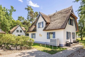 Ein traditionelles Chalet im Bergsportstil mit einem steilen Satteldach, zahlreichen Fenstern mit Fensterläden und einem gepflegten Garten.