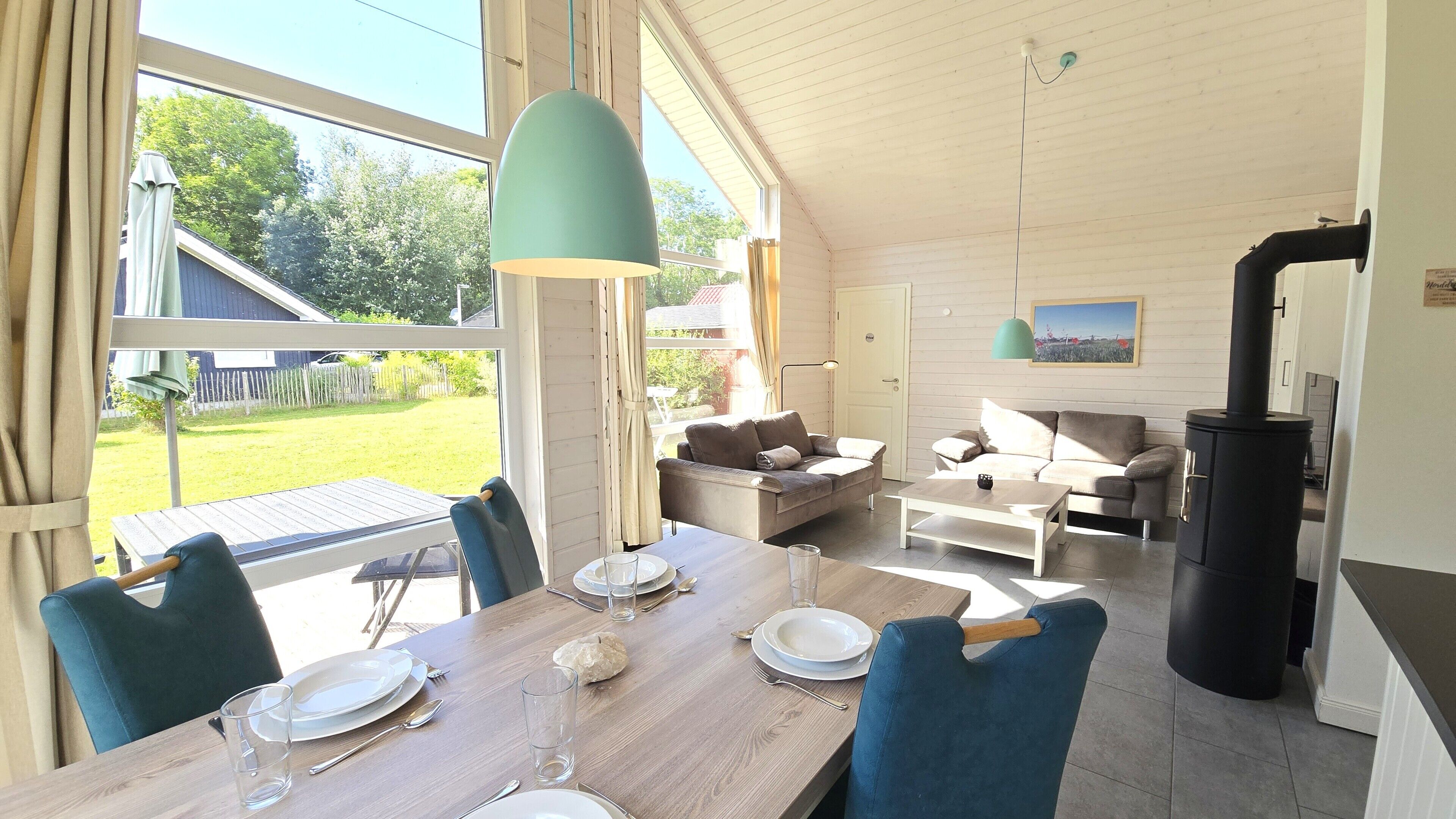 Un coin repas avec une table dressée pour quatre personnes, un canapé et une cheminée.