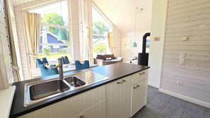 A kitchen with a large window, a sink, and a stove. - Kiek Ut Vacation Home – Baltic Sea, Sauna, and Vacations with Your Dog (Schönberg (Holstein))