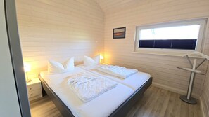 A room with two beds, a window with blinds, a bedside lamp, and a picture on the wall. - Kiek Ut Vacation Home – Baltic Sea, Sauna, and Vacations with Your Dog (Schönberg (Holstein))