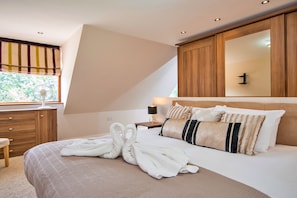 A bedroom with a bed, bedside table, and a window with curtains. - Bryncoch Retreat (Bryncoch)