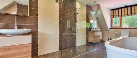 Ein modernes Badezimmer mit einem großen Waschbecken, einer Duschkabine und einer Badewanne.