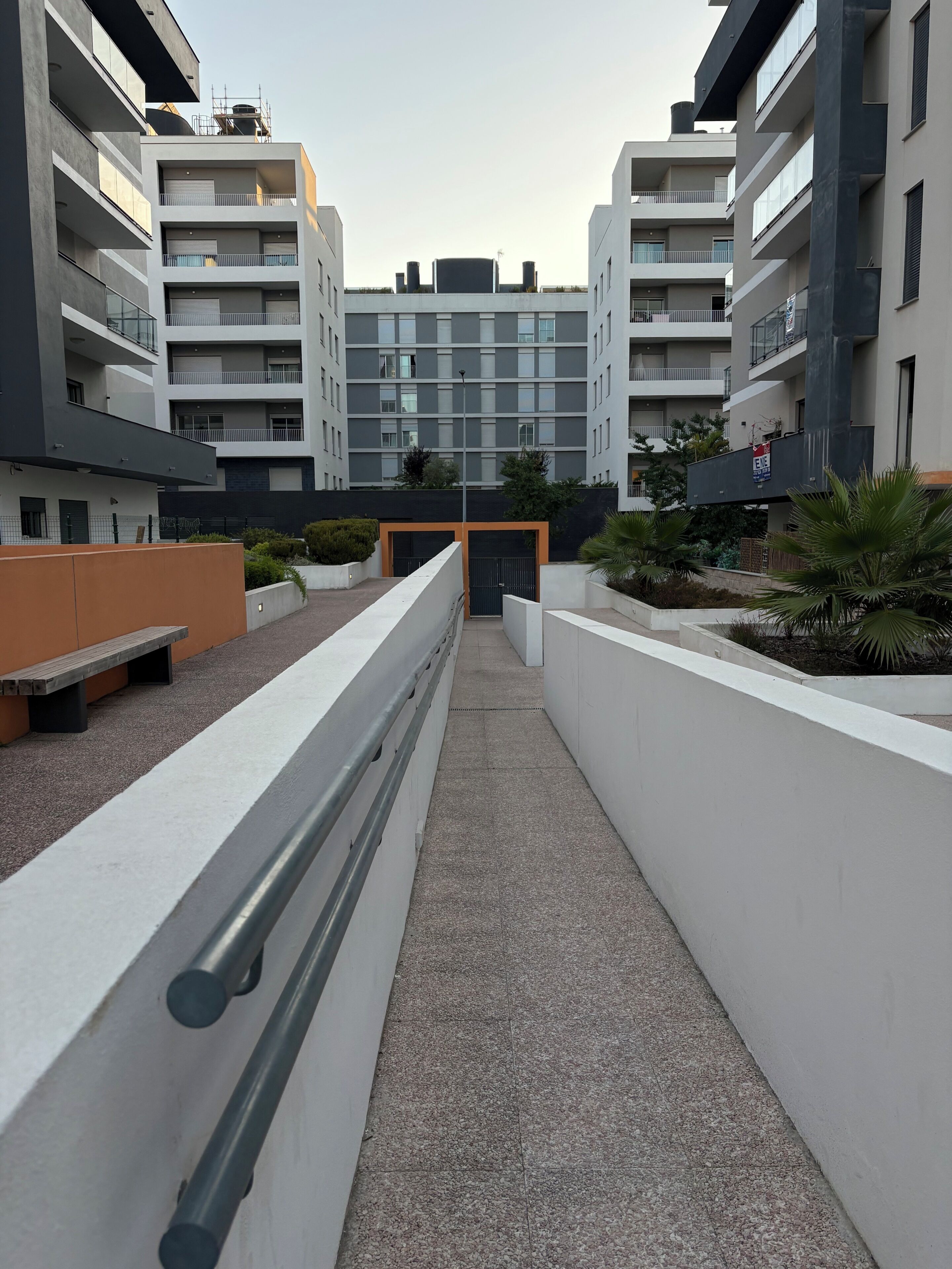 Un immeuble d’appartements moderne doté de nombreux balcons, d’une cour intérieure et d’une entrée sécurisée.