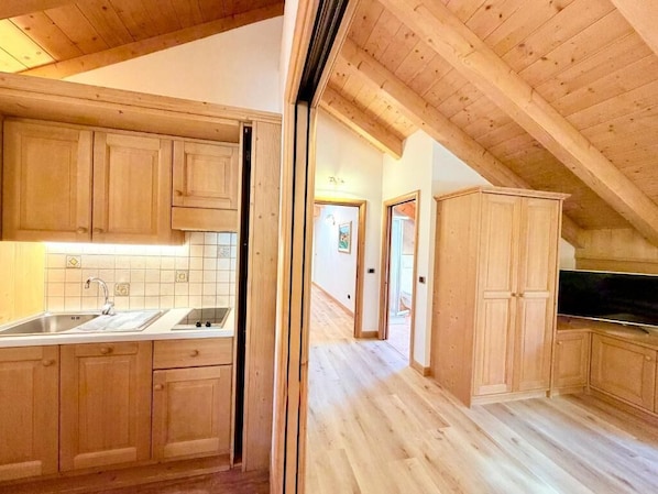 A kitchen with wooden cabinets, a sink, and a countertop.