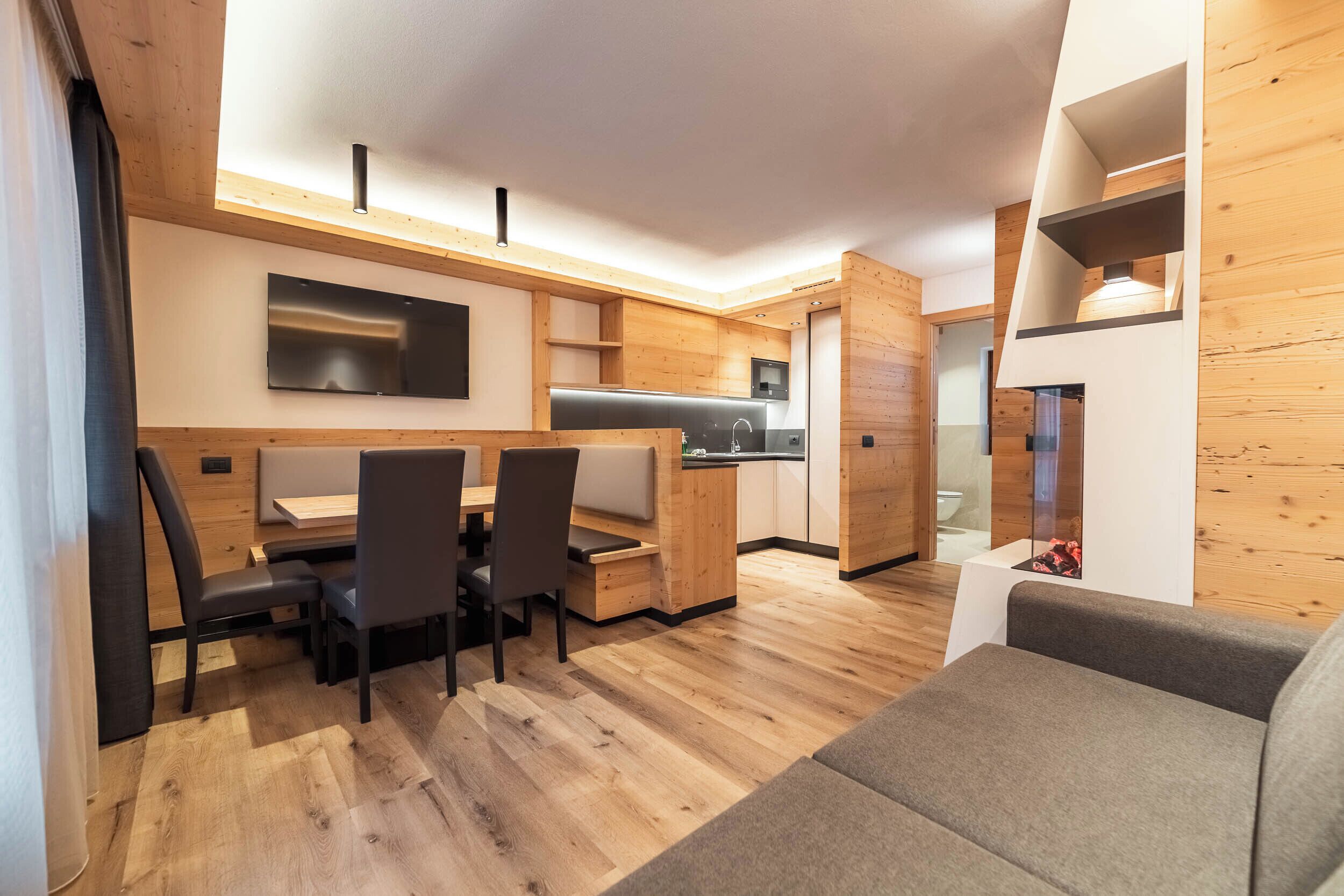 A compact living space with a dining area, kitchenette, and a seating area.