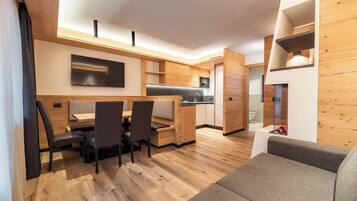 A compact living space with a dining area, kitchenette, and a seating area.