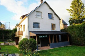 A two-story house with a covered porch, a stone staircase, and a garden with daffodils. - Gîte Premium Japonais 4★ - Clim & Borne VE - 4 min du Zoo de Beauval (Saint-Aignan)