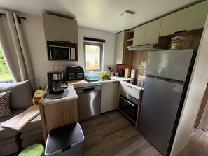 A compact kitchen with a microwave, coffee maker, and a refrigerator.